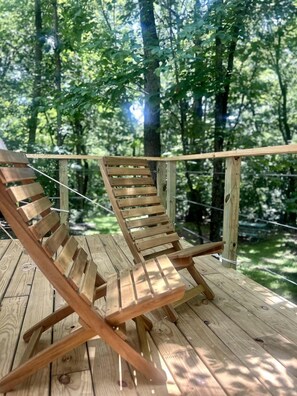 Eine Holzterrasse mit zwei Liegestühlen.