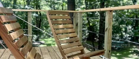 Una terraza de madera con dos sillones de jardín.