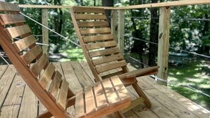 Una terraza de madera con dos sillones de jardín.