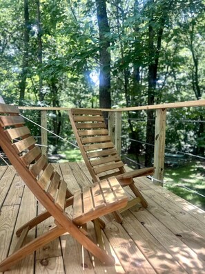 Una terraza de madera con dos sillones de jardín.