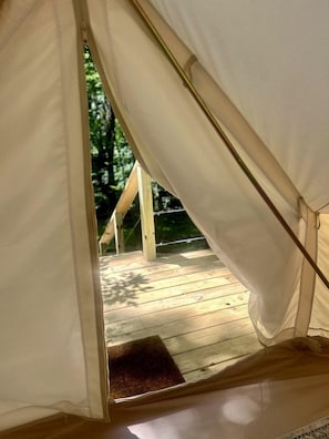 A tent with a wooden deck and a door.