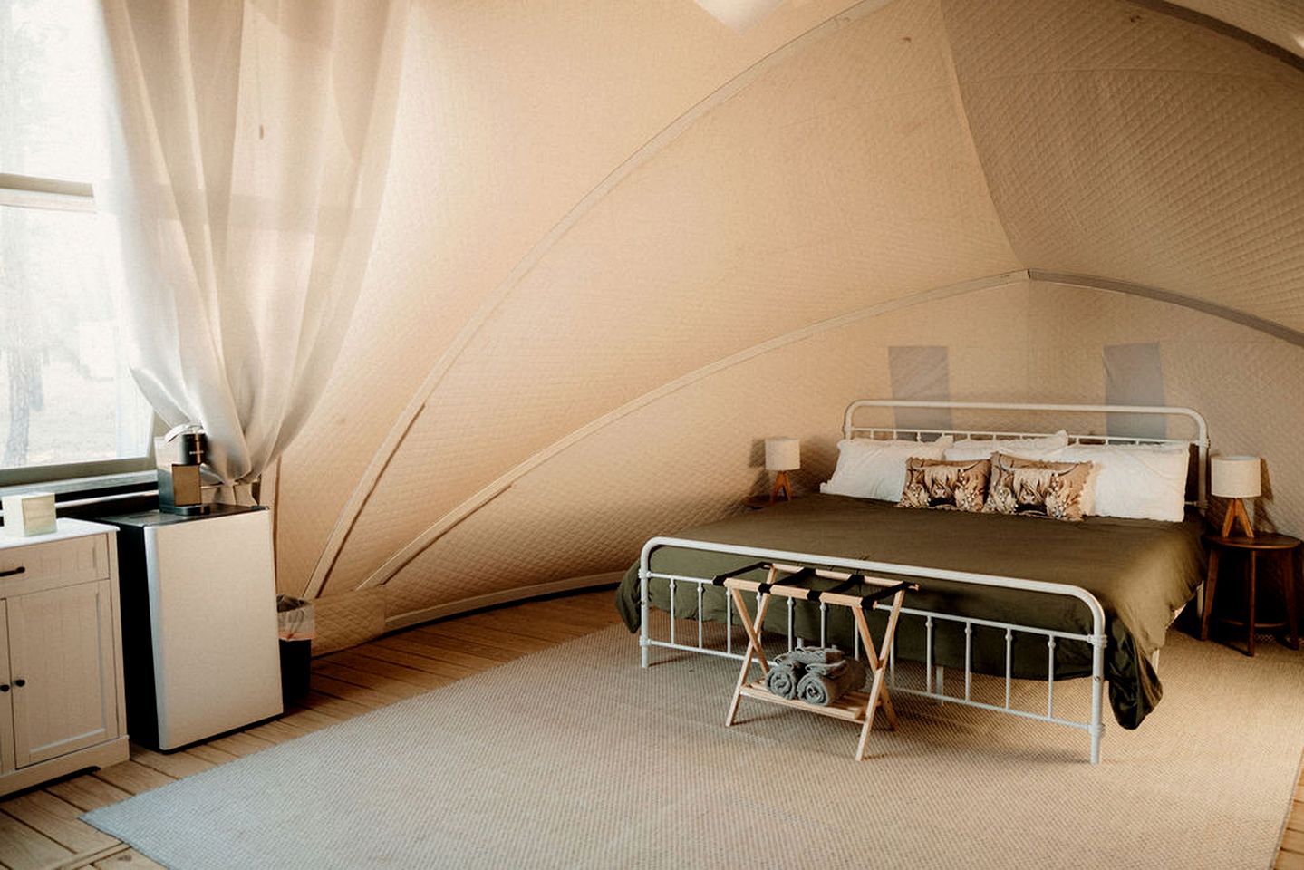 A tent-style bedroom with a bunk bed, a desk, and a chair.