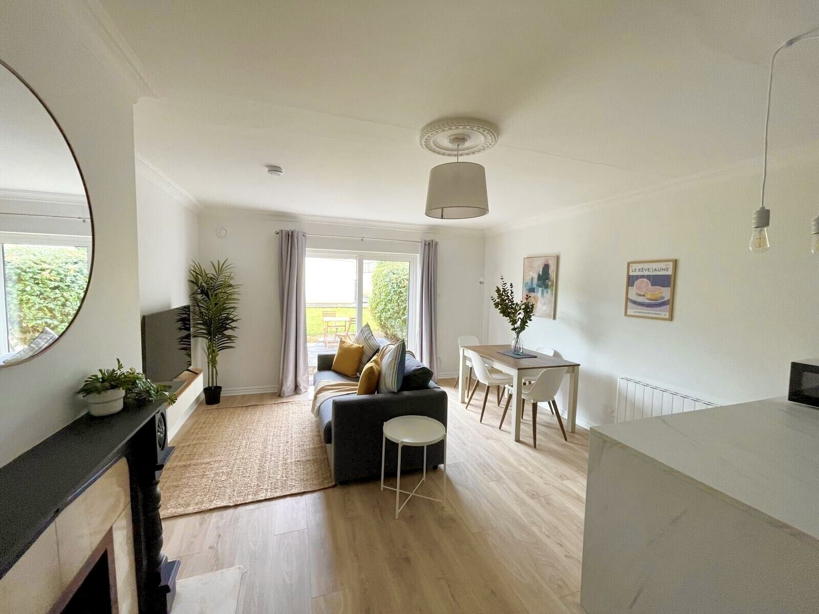 A modern living room with a sofa, dining table, and chairs.