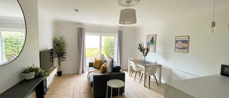 A modern living room with a sofa, dining table, and chairs.