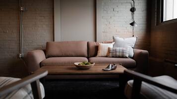 A modern living room with a brown sofa, a wooden coffee table, and a lamp.