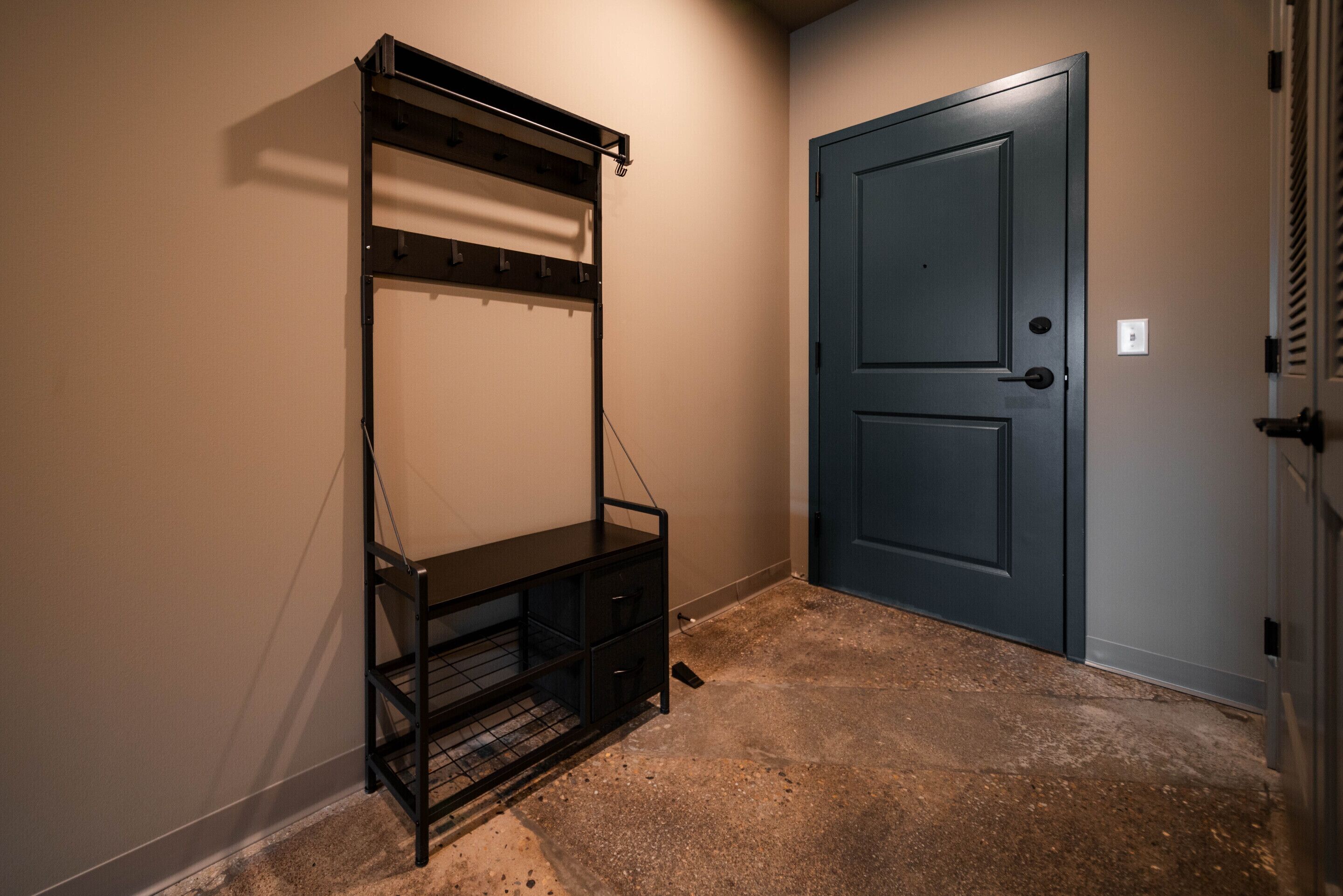 A room with a door, a metal shelf unit, and a concrete floor.