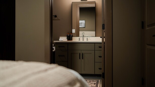 Une salle de bain d’hôtel avec un miroir, un lavabo et un porte-serviettes.