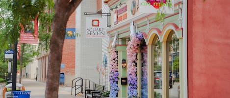 A street view with a coffee house named 'Square Seven Coffee House,' a sign for 'Art Gallery,' and a 'Michael W. Norris, Air Force Lancaster' sign.