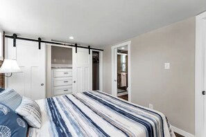 A bedroom with a bed, a wardrobe, and a walk-in closet. - Rustic Cabin Retreat with Loft, Fire Pit & Community Pool in Branson, Missouri (Branson)