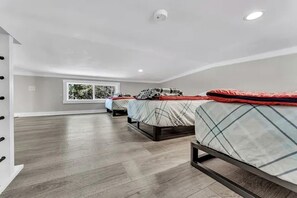 Ein geräumiges Zimmer mit großem Fenster, einer Deckenkamera und Holzboden.