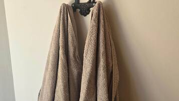 A pair of brown towels hanging on a wall-mounted rack.