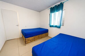 A room with a bed, a window with curtains, a door, and a tiled floor. - House with Pool 5 Minutes from Gaivotas Beach (Itanhaém)