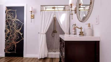 A modern bathroom with a skylight, a vanity with a mirror, and a shower area.