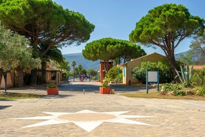 A paved pathway leading to a building with a star-shaped design, surrounded by trees and a clear sky.