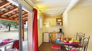 A compact kitchen with a dining area, a refrigerator, and a microwave. - Charmant T3 au cœur d’un domaine de 6 ha | Piscine (Sauve)