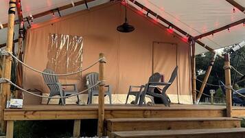 A covered outdoor seating area with chairs and a fire pit.