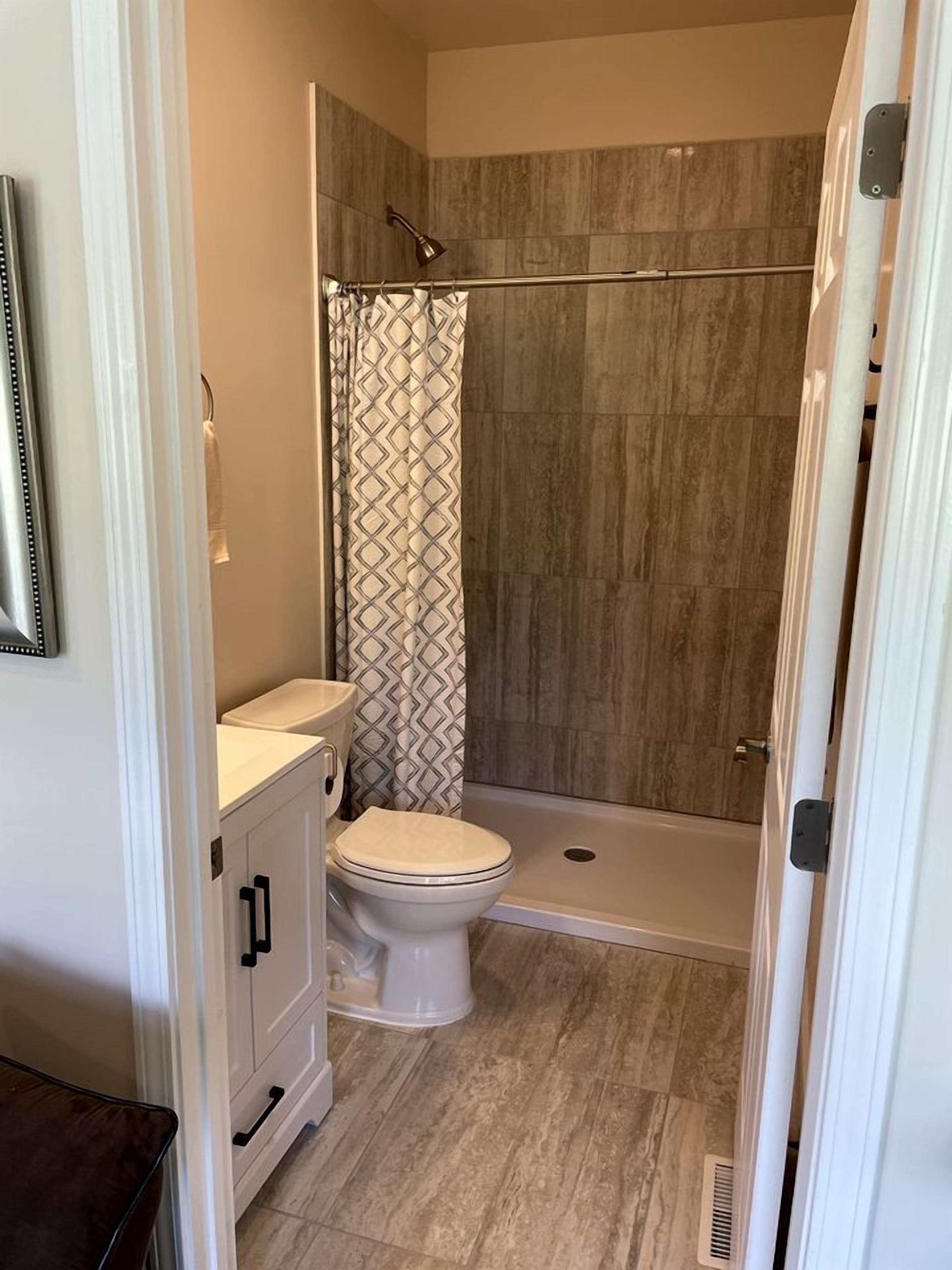 A bathroom with a shower, toilet, and vanity.