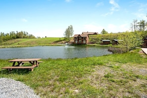 Een landhuis aan het meer met een picknicktafel en een klein steiger.