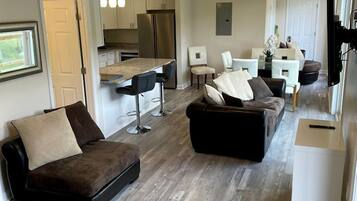 A modern living room with a sofa, a coffee table, and a TV.