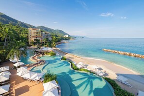 Ein Resort mit Pool, Strand und Bergblick.