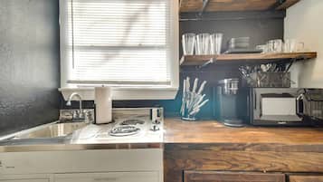 A kitchen with a sink, stove, and microwave.