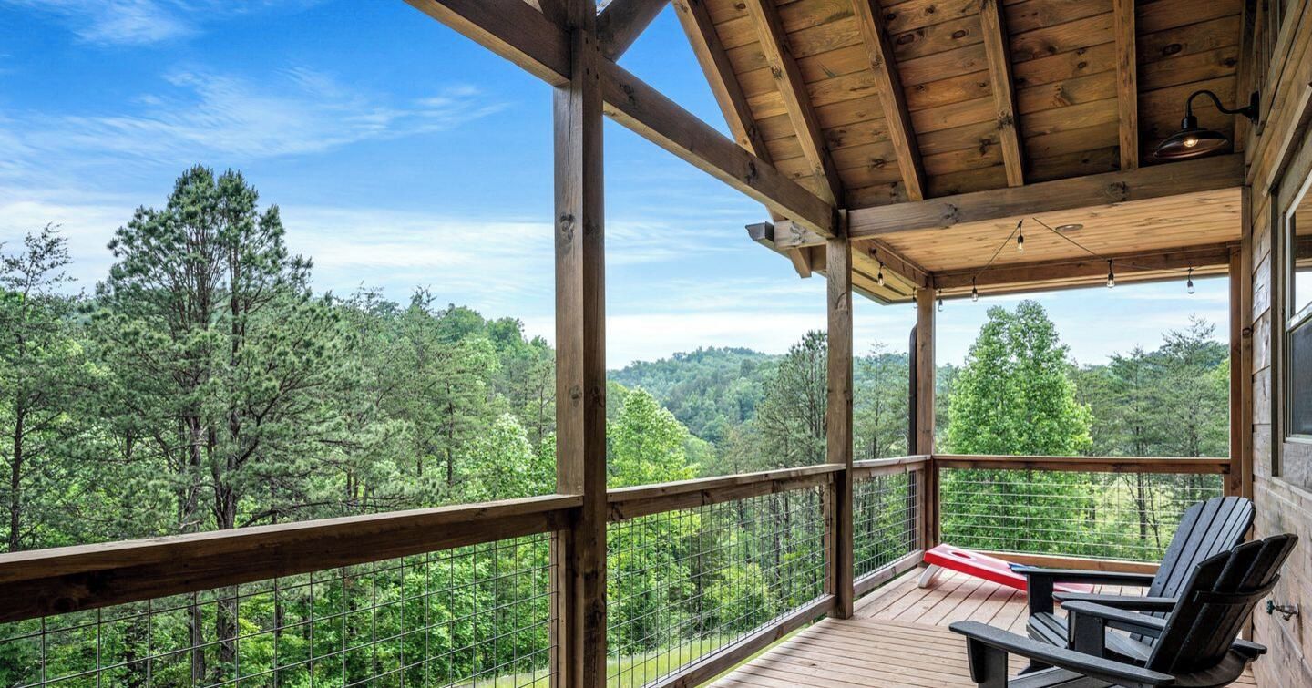 A wooden deck with a view of a forest.