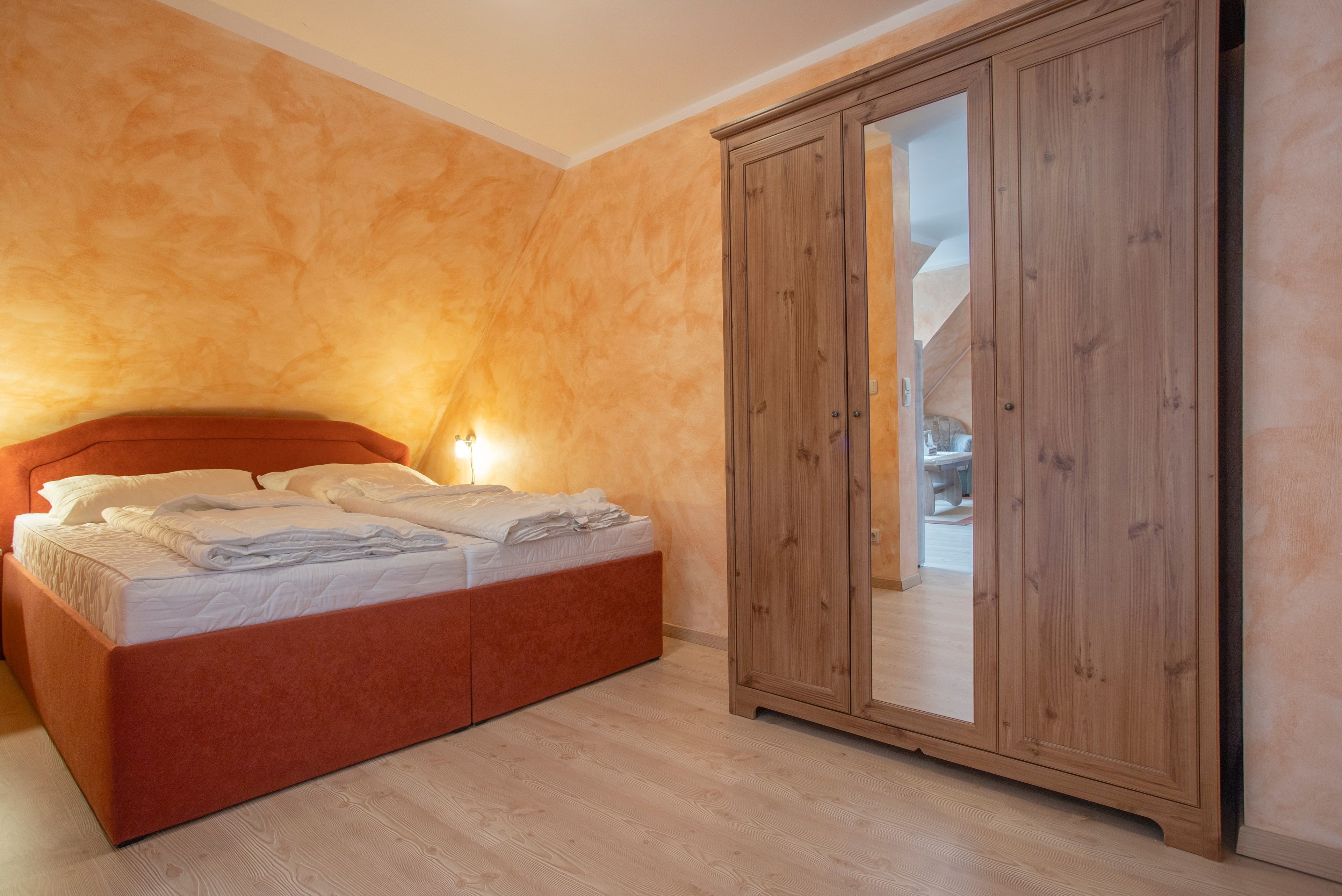Ein Schlafzimmer mit einem Bett, einem Holzschrank und einem Nachttisch.