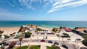 A coastal area with a beach, tents, and a parking lot. - Apartment Praia Rocha | Sea | Concorde Infinity (Portimão)