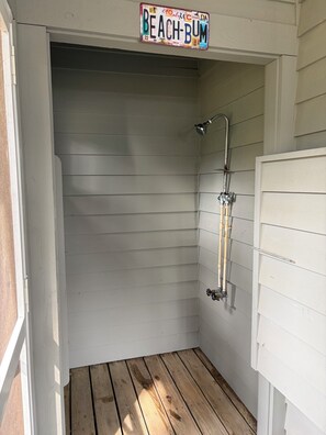A small, enclosed shower area with a wooden floor and a metal showerhead. - Bethany Coastal Retreat, Fully Updated Home, Pool Access & under 1 mile to Beach (Bethany Beach)
