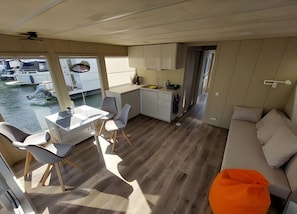 A compact boat interior with a dining area, kitchen, and seating space.