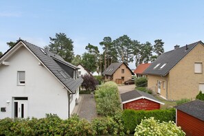 Uma área residencial com casas, um galpão vermelho e um caminho.