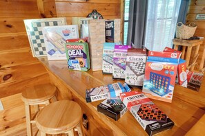 A wooden bar area with various board games and a checkered game board. - Log Cabin near Pigeon Forge | Hot Tub, Fireplace (Sevierville)
