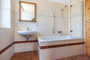 A bathroom with a white sink, a bathtub, and a shower. - Apartment '8 Og' with Private Garden and Balcony (Röbel)