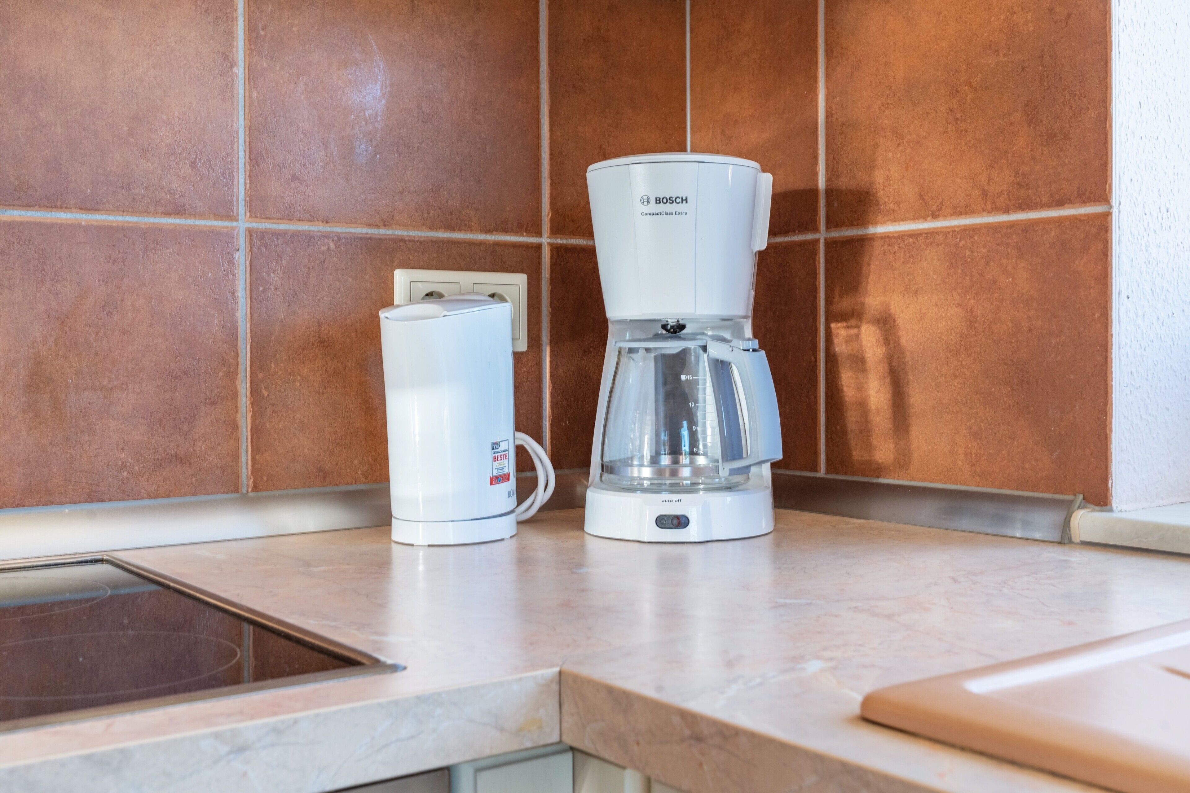 Eine Küche mit Kaffeemaschine und Wasserkocher auf der Arbeitsfläche.