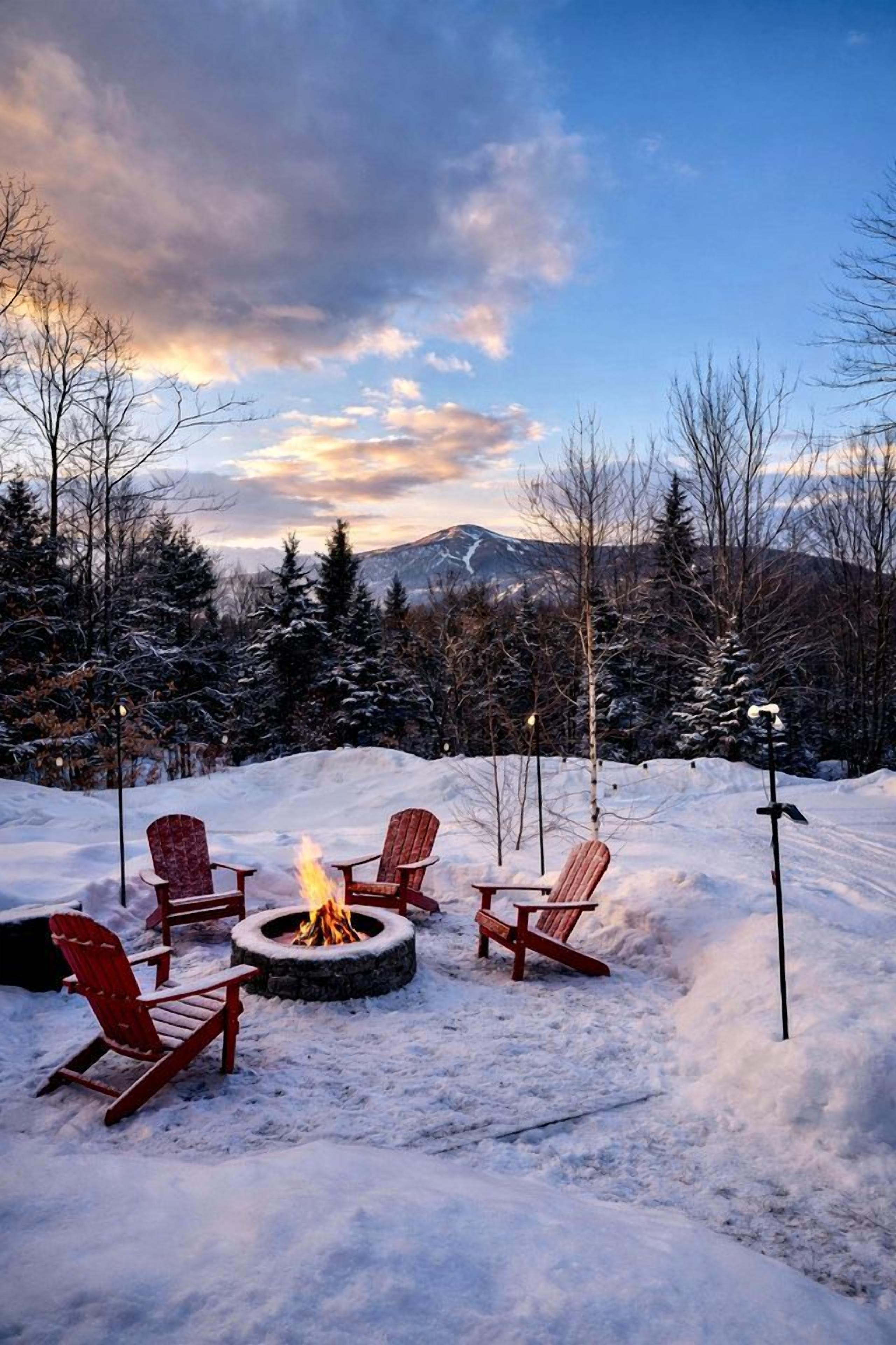Zona esterna innevata con un braciere e quattro poltrone Adirondack.
