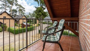 A balcony with two wicker chairs and a view of a residential area. - Apartment 'Haus 19 OG' with Private Garden, Balcony and Wi-Fi (Röbel)