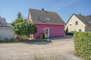 A residential area with houses, a driveway, and a small tree. - Holiday Home 'Haus K 95' with Private Terrace, Private Garden and Wi-Fi (Röbel)