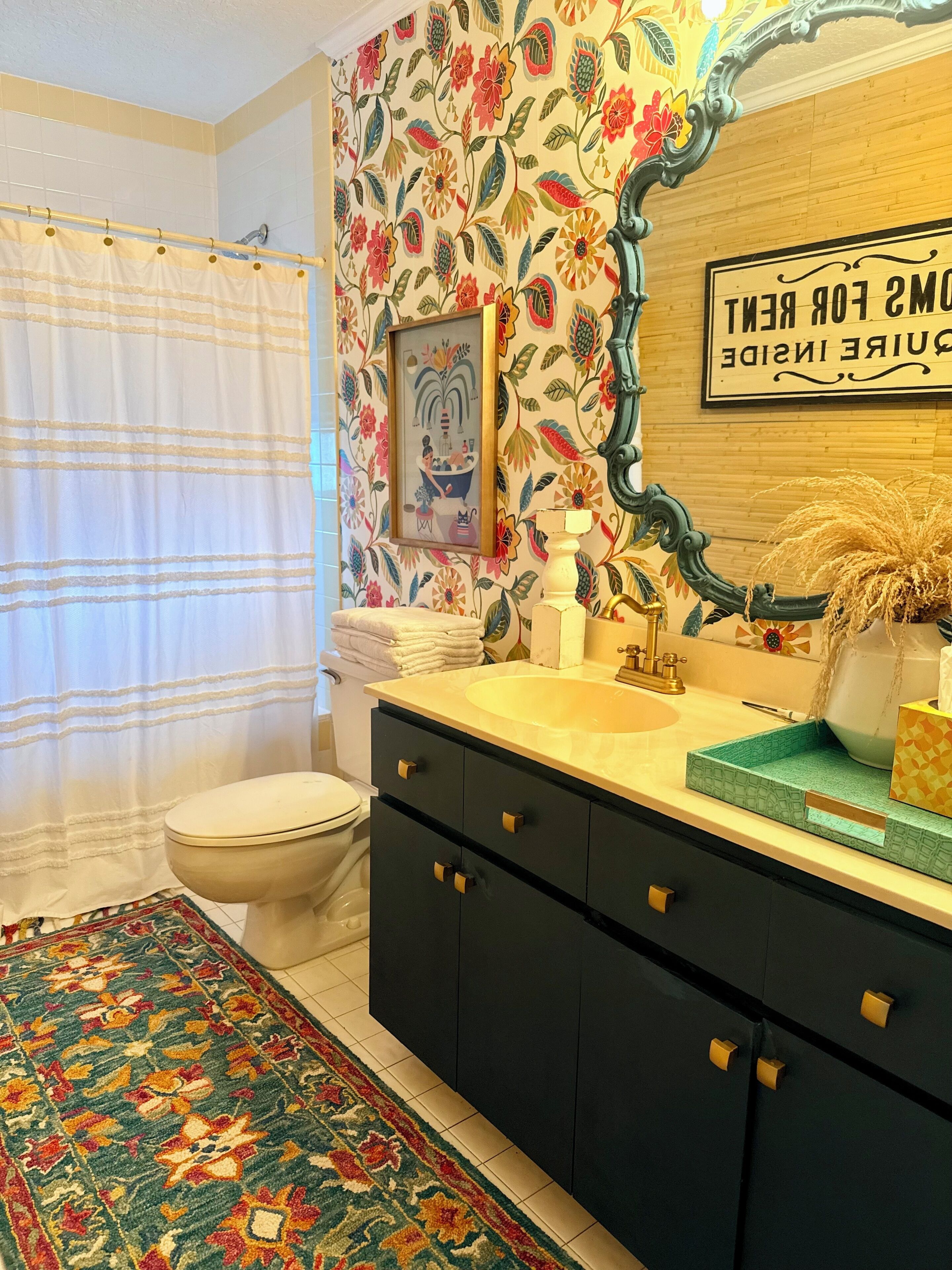 Un baño con inodoro, lavamanos y cortina de ducha.