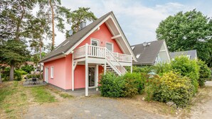 Kaksikerroksinen talo, jossa on parveke ja katettu kuisti.