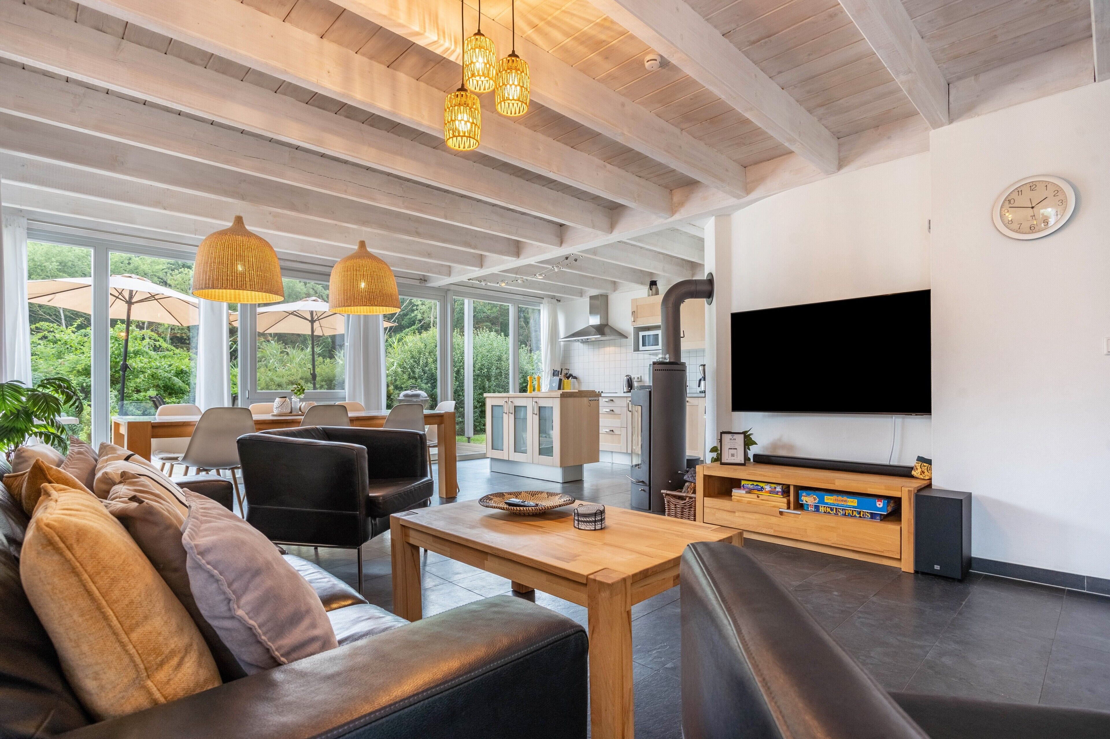 A modern living room with a sofa, dining area, and kitchen.