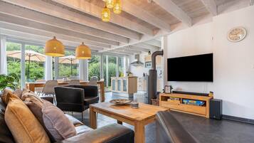 A modern living room with a sofa, dining area, and kitchen.