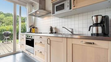 A modern kitchen with a built-in oven, microwave, and coffee maker.
