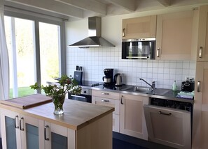 A modern kitchen with a built-in microwave, a coffee maker, and a sink. - Holiday Home 'W 7' with Private Terrace, Private Garden and Wi-Fi (Röbel)