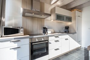 Uma cozinha moderna com micro-ondas, cafeteira e forno.