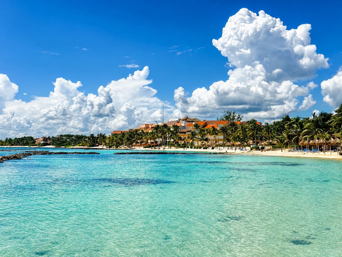 On the beach, white sand, sun loungers, beach umbrellas