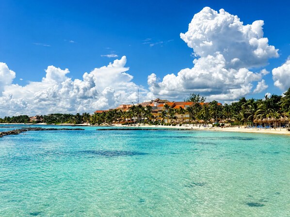 On the beach, white sand, sun-loungers, beach umbrellas - Beachfront condo with loft and sea views (Puerto Aventuras)