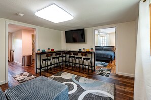 Ett kompakt bostadsutrymme med ett köksområde, ett matbord med stolar, en soffa och en säng.