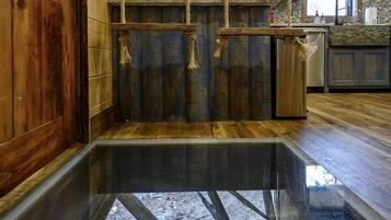 A wooden interior with a glass floor, wooden cabinets, and a window.