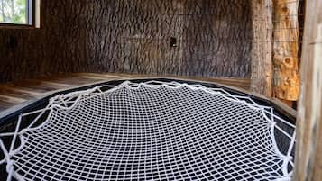 A room with a circular netted floor, wooden walls, and a window.