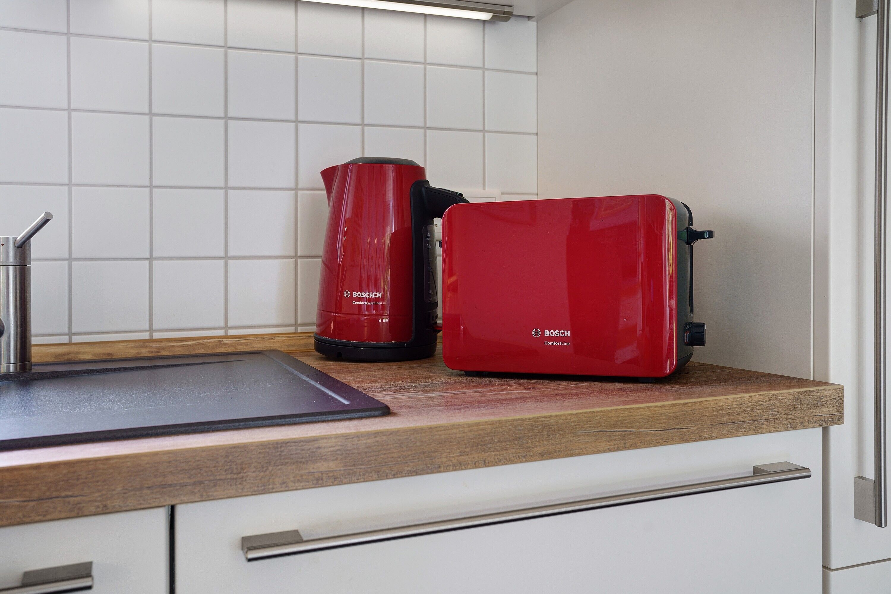 A kitchen with a Bosch coffee maker and a red appliance on the counter.